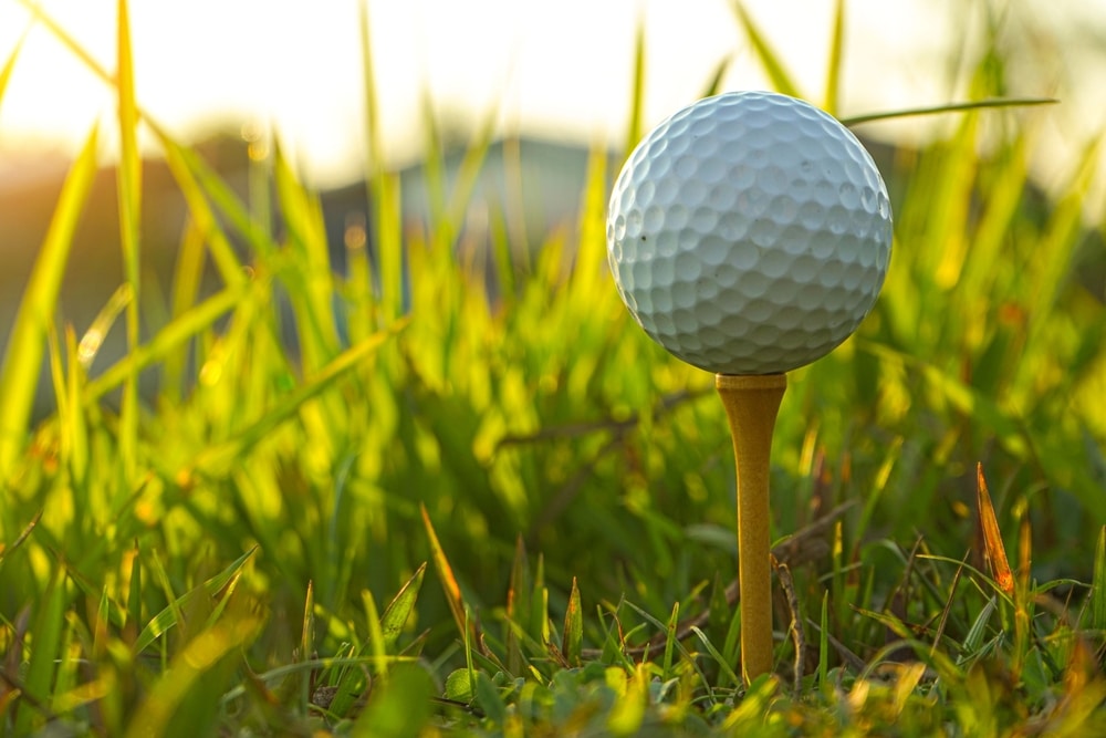 Golf,ball,is,on,tee,at,green,lawn,in,a