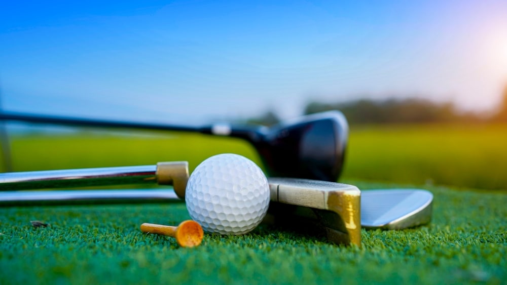 Golf,clubs,and,golf,balls,on,a,green,lawn,in