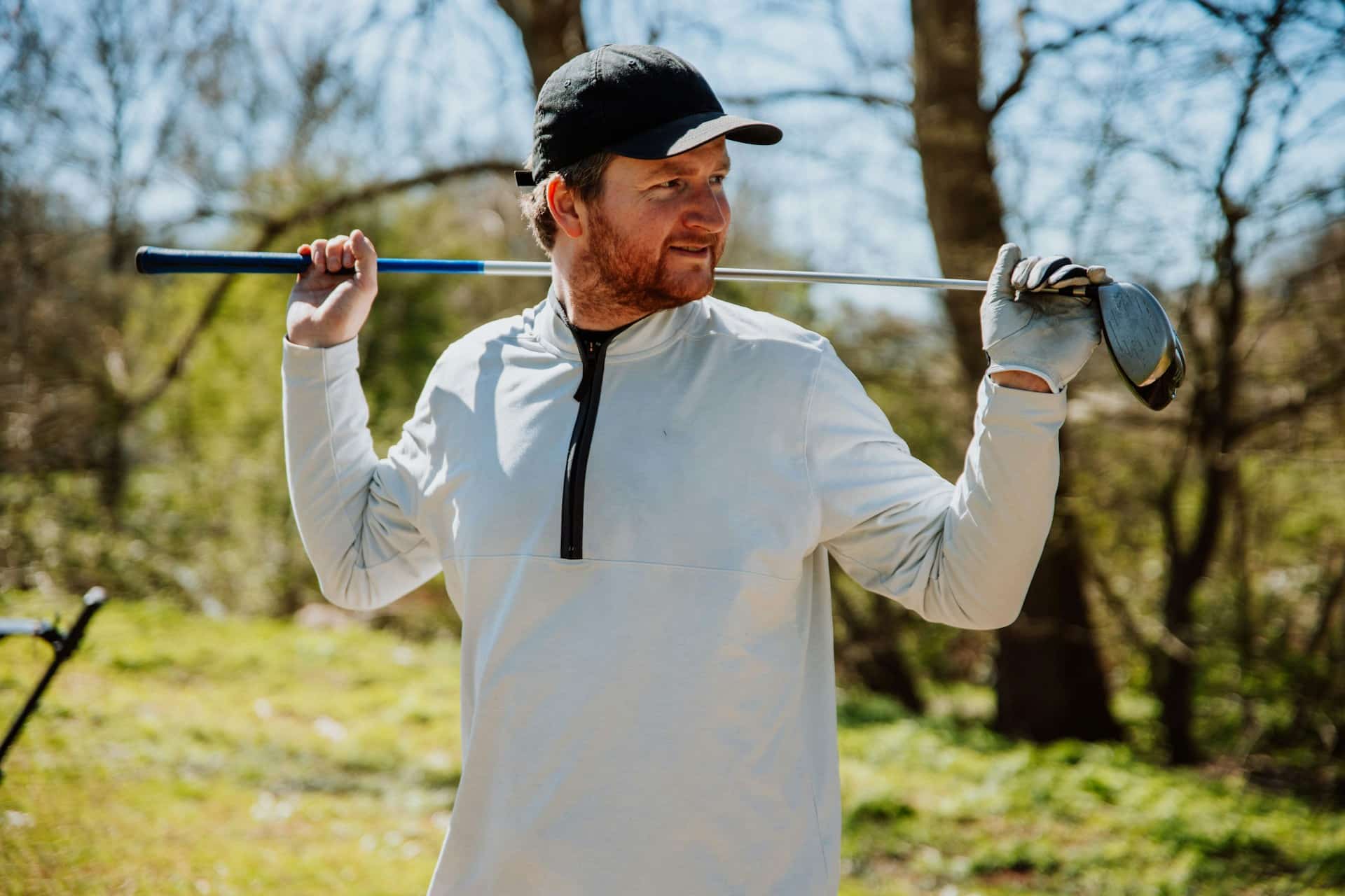 a-man-holding-a-golf-club-in-his-right-hand