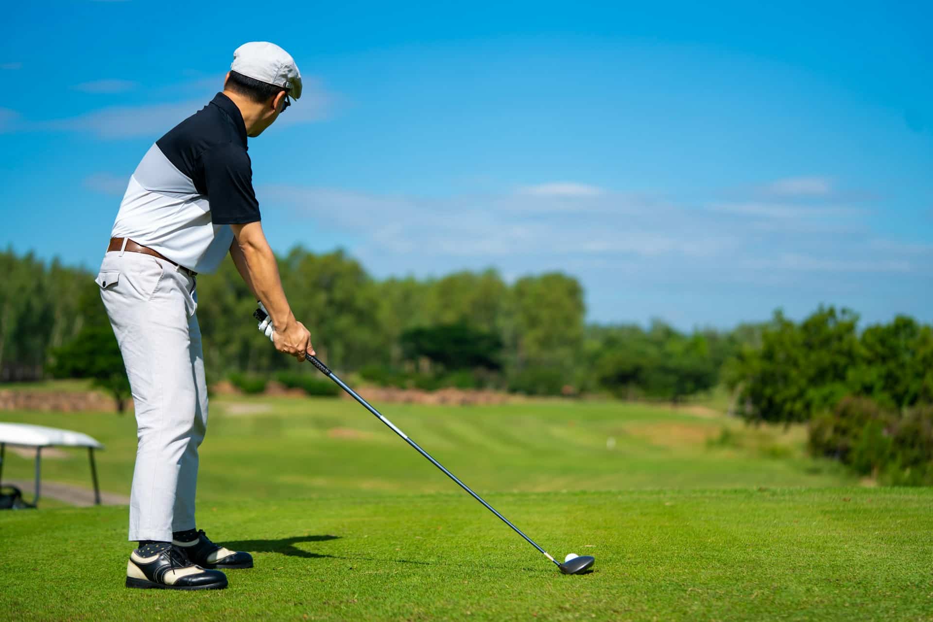man-golfer-holding-golf-club-hitting-golf-ball