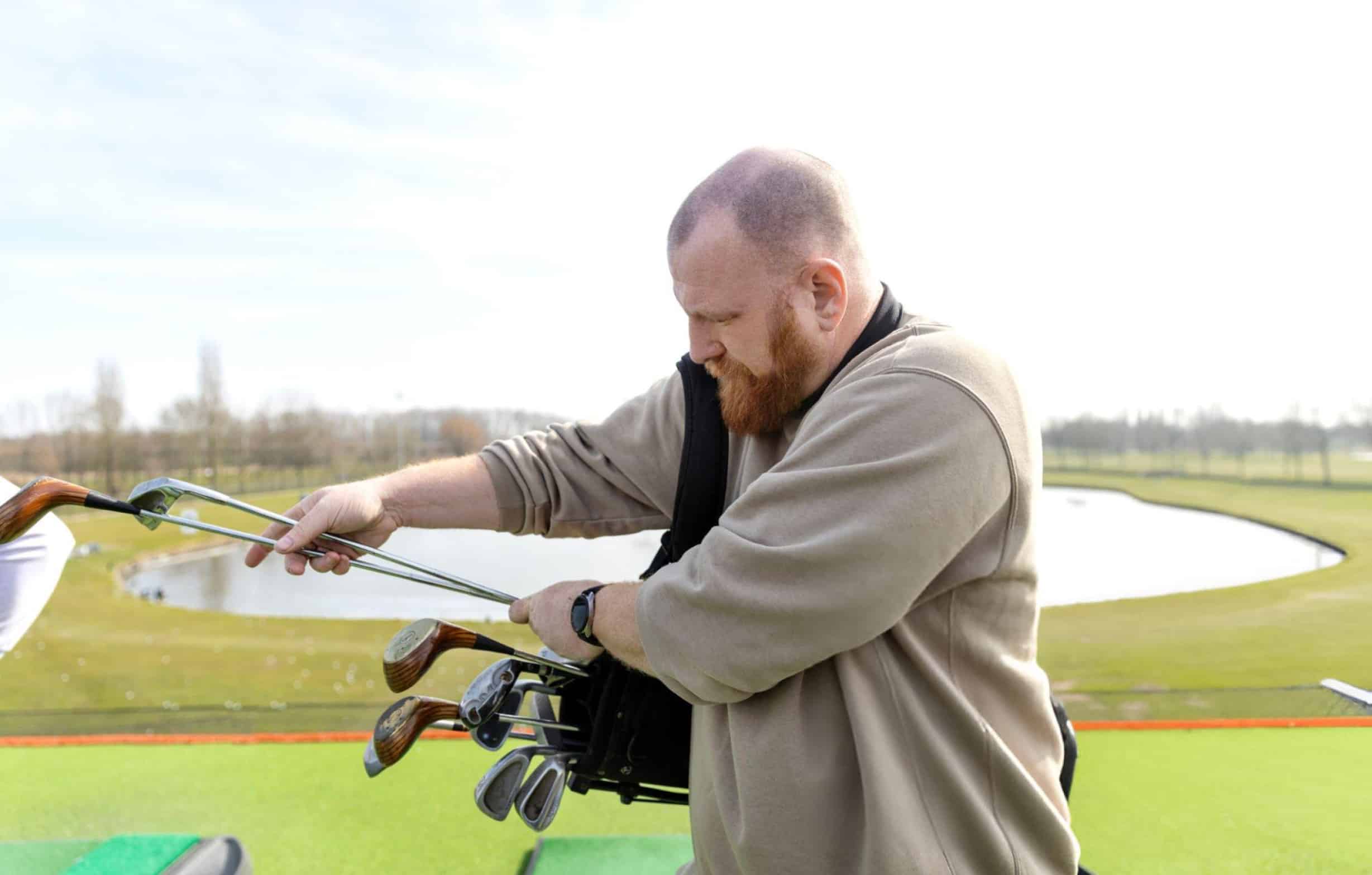 man choosing and holding golf shafts